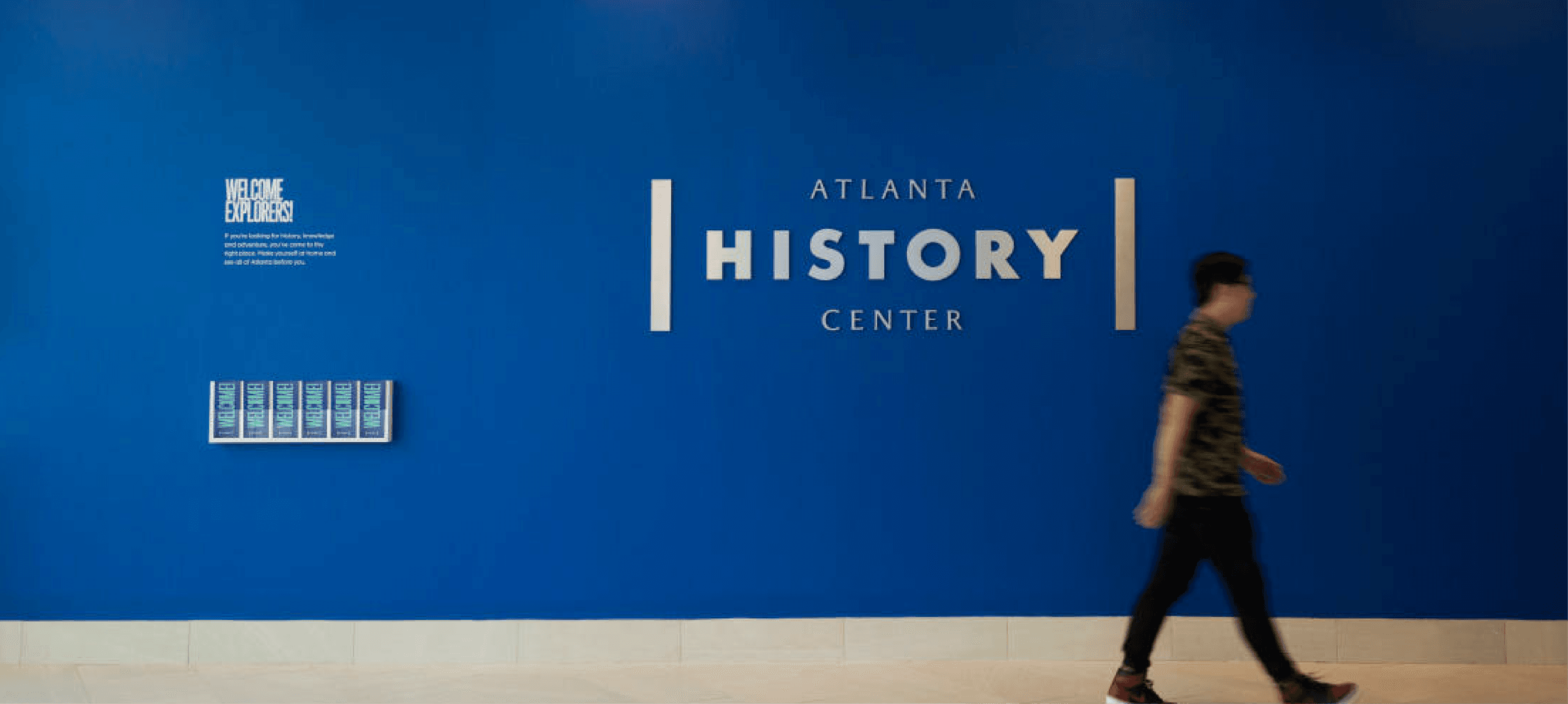 The iconic blue feature wall at the Atlanta History Center lobby, displaying the museum’s modern logo and welcoming guests to explore Atlanta’s history.