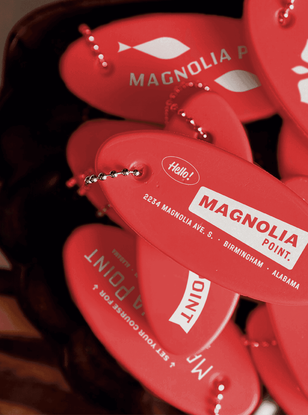 Red key floats with branding. A pile of bright red Magnolia Point key floats featuring the restaurant’s logo and address.