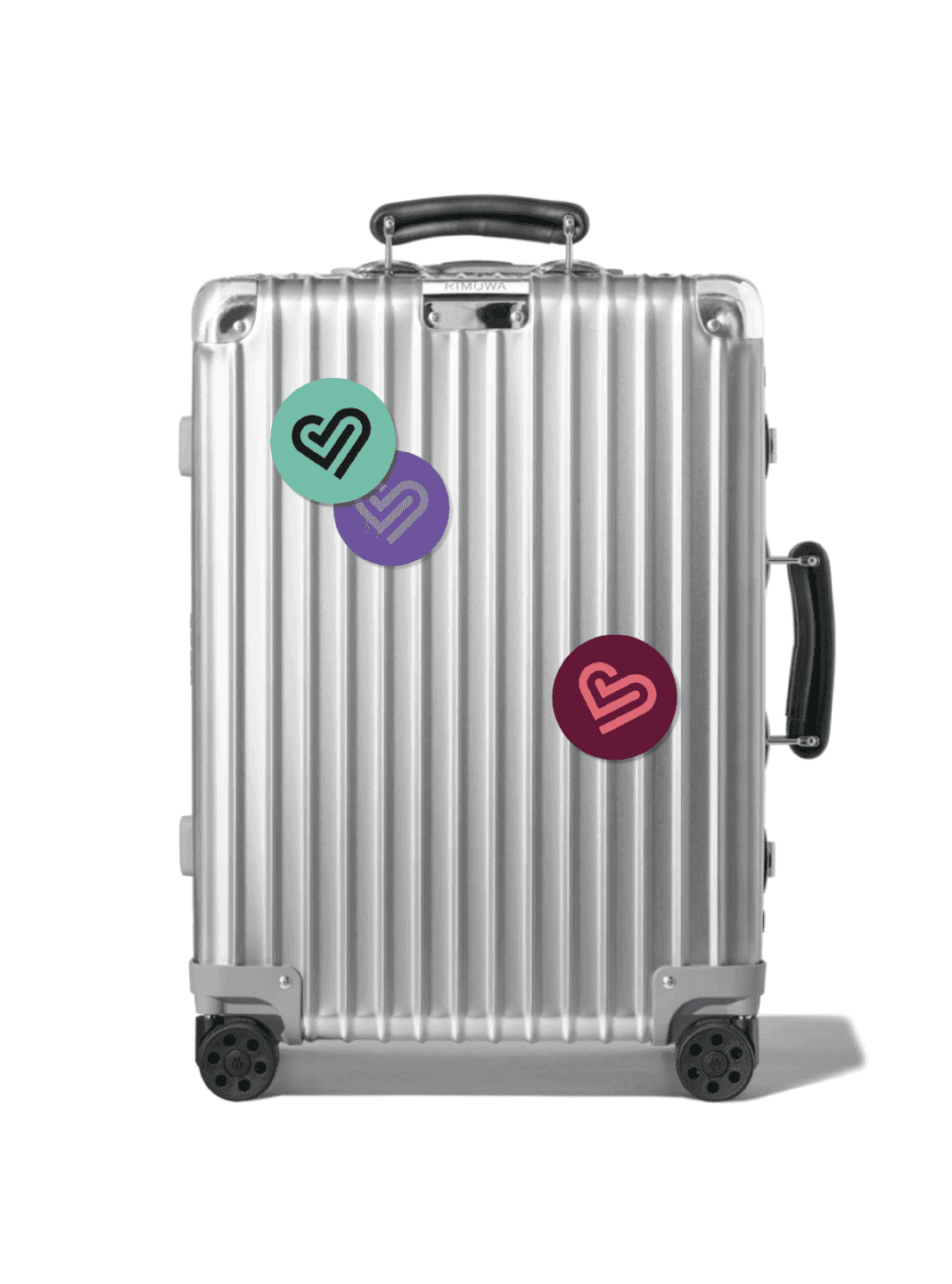 Suitcase Stickers. A silver Rimowa suitcase decorated with colorful circular Trainline heart-logo stickers.