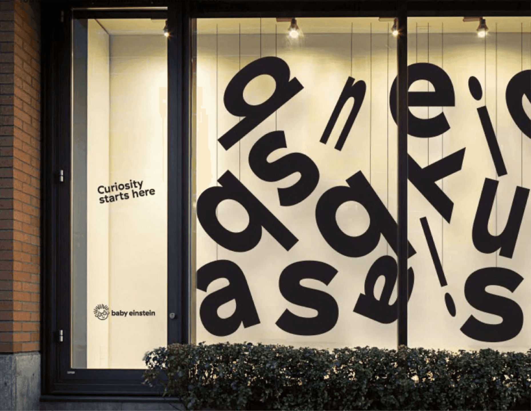 Baby Einstein window display. A Baby Einstein storefront covered in large, tilted black letters with the tagline “Curiosity starts here.”